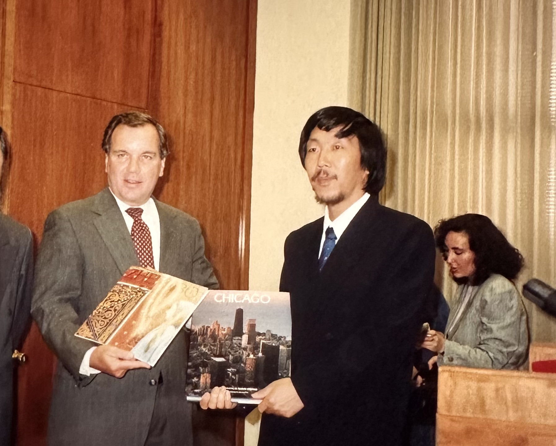 Zheng Bo during a Sister Cities cultural exchange in Chicago, holding a Chicago book while presenting his art book, 1993.